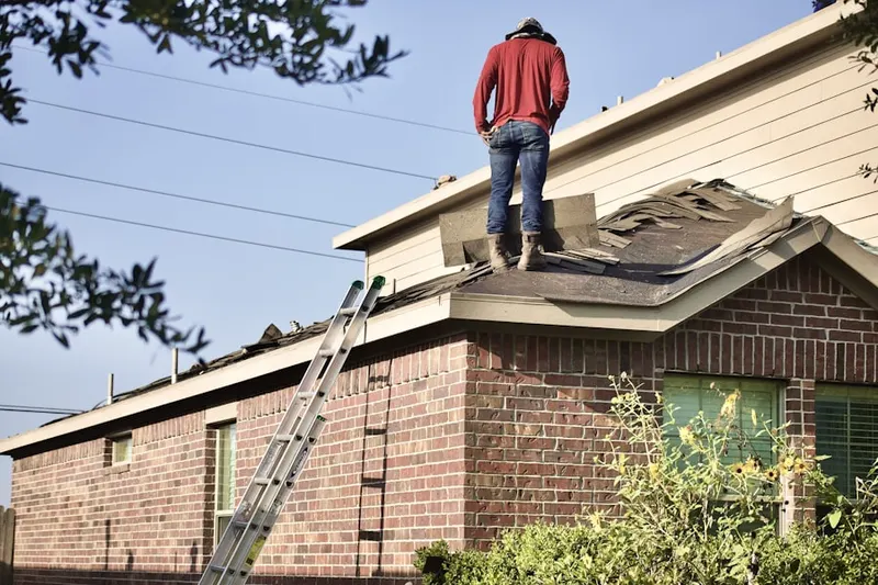 Professional roofer working on a residential roof in Academy Park
